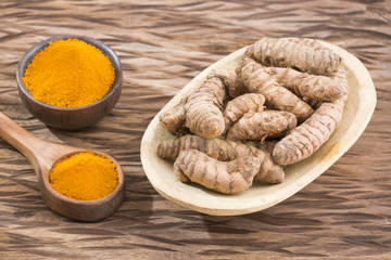 Turmeric powder and fresh turmeric on wooden background. Curcuma longa
