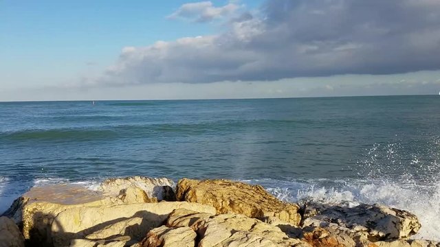 Waves crashing on seawall rocks in Denia, a Mediterranean Sea port in the Alicante province, on Costa Blanca, Spain. 
