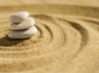Fototapeta na wymiar zen meditation stone in sand, concept for purity harmony and spirituality, spa wellness and yoga background