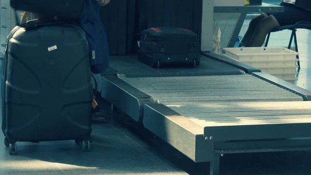 Businessmen take their luggage after passing security control at the airport