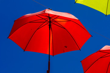 Colourful umbrellas urban street decoration. Hanging colorful umbrellas over blue sky, tourist attraction