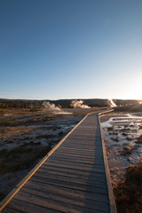Sunset over boardwalk at the Old Faithful geyser basin in Yellowstone National Park in Wyoming United States