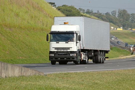 no brand flat nose white semi truck on major highway