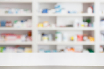 Pharmacy drugstore counter table with blur abstract backbround with medicine and healthcare product on shelves