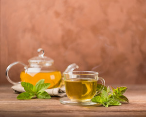 A cup of fresh hot tea with mint on a dark background. The concept of a healthy diet. Front view. Copy space