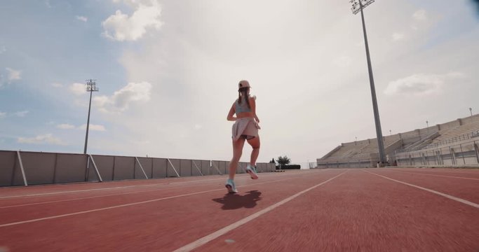 Young athletic woman running and doing sports track training