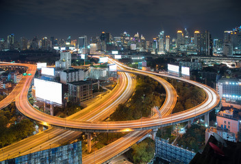 Fototapeta na wymiar Bangkok City with Curved Express Way and Skyscraper. Top View of City Elevated Highway with Car Traffic Light Trial at Twilight Time.