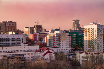 city view from above during the sunset with the pink and yellow sky on the background