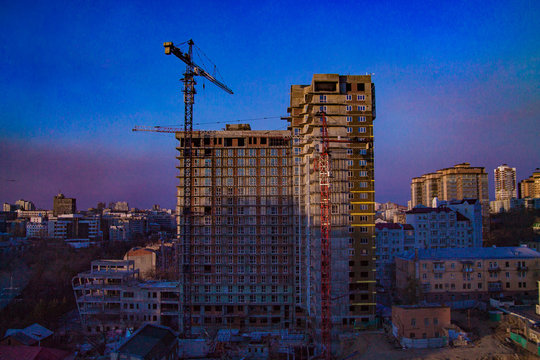 crane near a tall building on a constructin site in the city on bluesky background