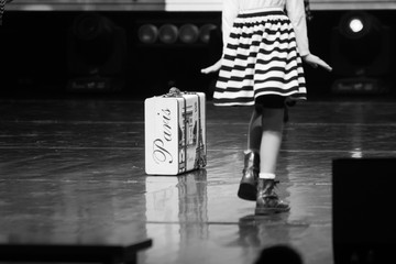black and white photo of a black and white photo of a suitcase with lower parts of models posing on a runway