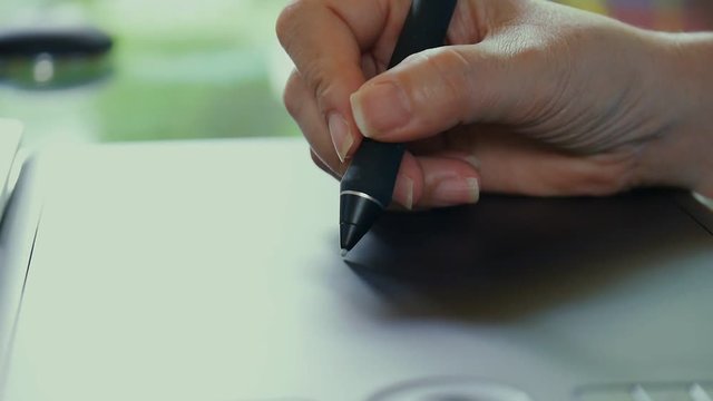 Tablet and pen . Woman hand drawing digital pen tool on  tablet surface for images and video post production process, hd video.
