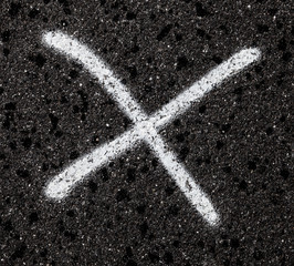 Weißes Kreuz auf Asphalt
