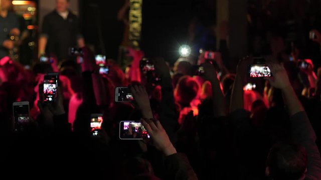 Spectators people crowd raising hands shoot mobile phones video of free music concert