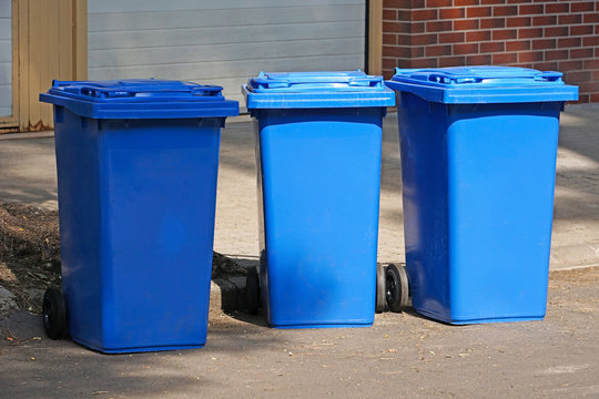 Blue garbage cans on the street