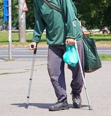 Old man walks with crutch
