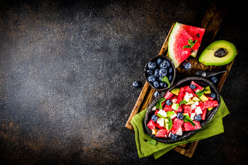 Summer food concept, fresh cold watermelon salad with feta cheese, blueberry, avocado and mint,...