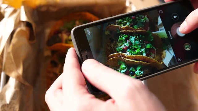 Food photo with a mobile phone a guy in Mexican cuisine restaurant takes pictures for social media