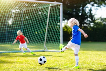 Fotobehang Voetbal Kids play football. Child at soccer field.  © famveldman