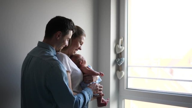 New parents young couple mother and father learn to take care about newborn baby at home