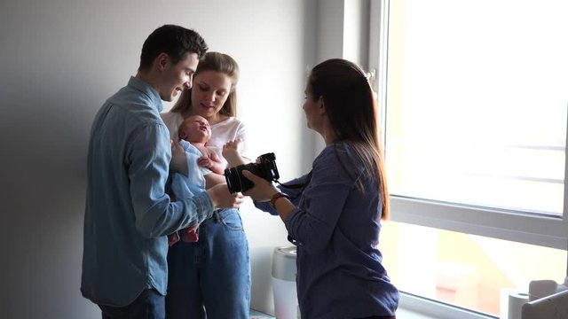 Professional photographer entrepreneur woman takes pictures on family photosession at home