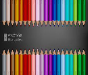Rows of rainbow colored pencils on dark grey background.