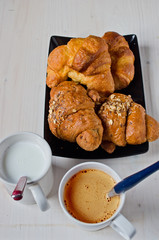 croissants with butter and cereals with a cup of cappuccino