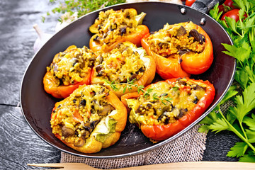 Pepper stuffed with mushrooms and couscous in pan on board
