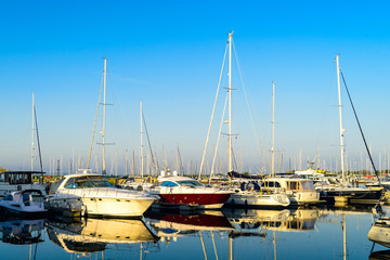 Fototapeta premium Modern sailboats and luxury yachts parked in the seaport on summ