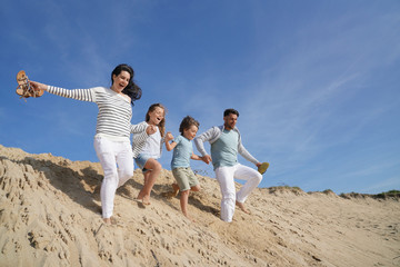 Family running down sand dune © goodluz