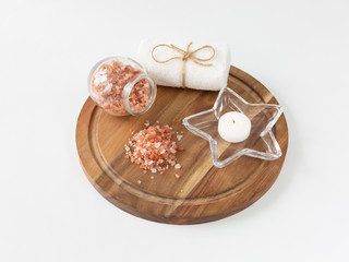 Beautiful pink Himalayan salt and towel on wooden plank. Relaxation and spa concept.