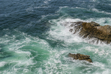 View of foam in green blue water during windy weather, beautiful ocean background