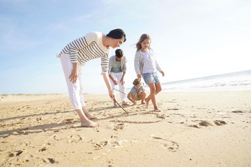 Family having fun writing messages on sandy beach