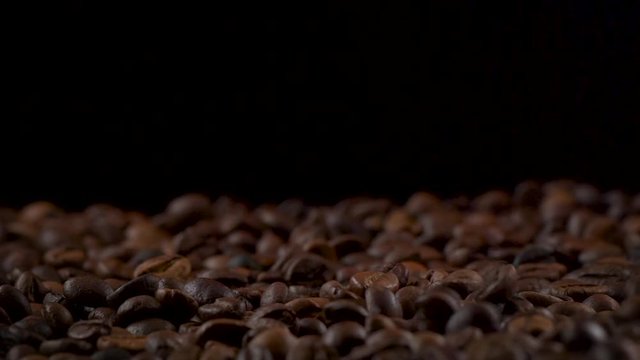 HD video of roasted aroma coffee beans over black background 