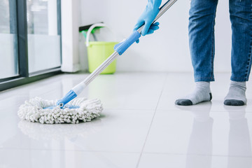 Housekeeping and cleaning concept, Happy young woman in blue rubber gloves wiping dust using mop...