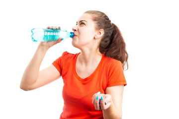 Young thirsty woman hydrating by drinking water from bottle.