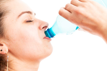 Close-up of young woman drinking water from plastic bottle.