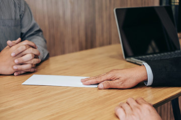 Hand of employer filing final remuneration to employee, letter of resignation, resign concept