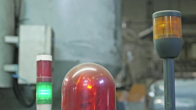 Warning light on a processing machine. Closeup flashing red lamp on machine in toilet paper production plant large workshop. Red siren on metal cabinet. Warning light for safety on work area.