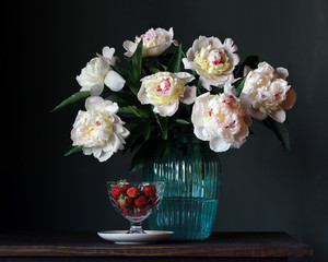 bouquet of white peonies in vase and strawberries.