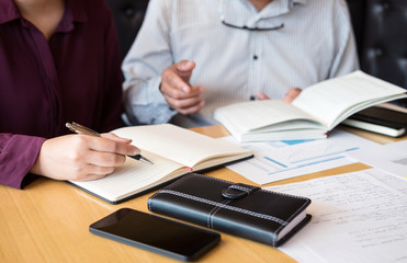 Education, teaching, learning, technology and people concept. Two high school students or classmates with helps friend catching up workbook learning in classroom, Tutor books with friends