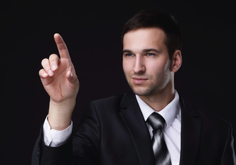 businessman pointing to a blank spot.isolated on a black background.