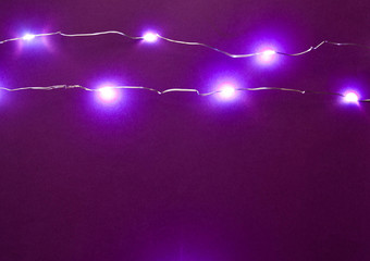 Lamp garlands on a violet black background. New Year's concept