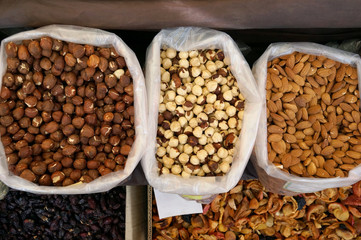Fresh peeled walnuts, hazelnuts and raisins in the street market. Nut kernel. The concept of organic food