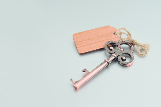 Decorative metal key stock images. Decorated key isolated on a silver background. Romantic key with wooden label