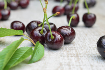 Spelled cherries on the white wooden background