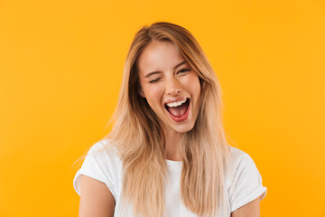 Portrait of a cheerful young blonde girl winking