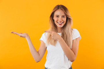 Portrait of a cheerful young blonde girl holding copy space