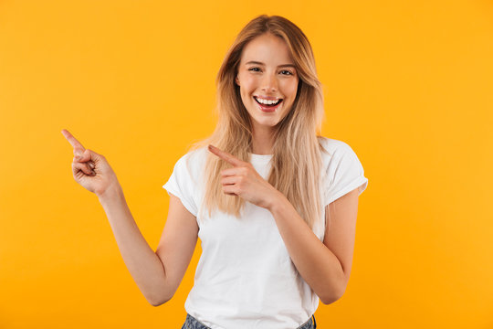 Portrait of a joyful young blonde girl pointing
