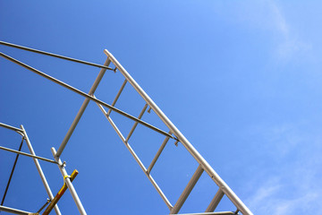 Silhouette of construction workers on scaffold working under a blue sky