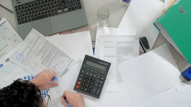 Financier calculating company's profit in office.